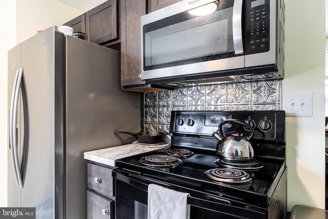 kitchen with appliances with stainless steel finishes, backsplash, and dark brown cabinets