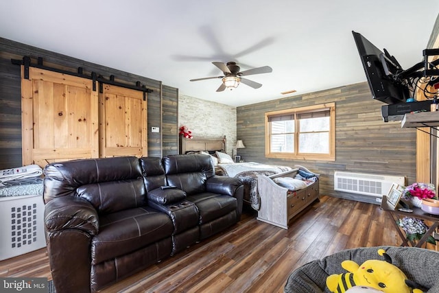 bedroom featuring a barn door and dark wood-style flooring