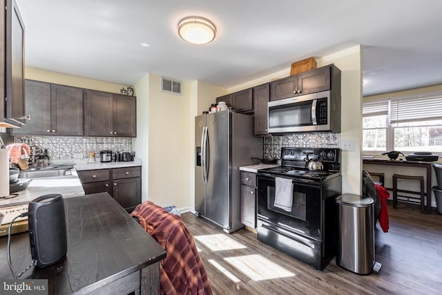 kitchen with light countertops, appliances with stainless steel finishes, a sink, and visible vents