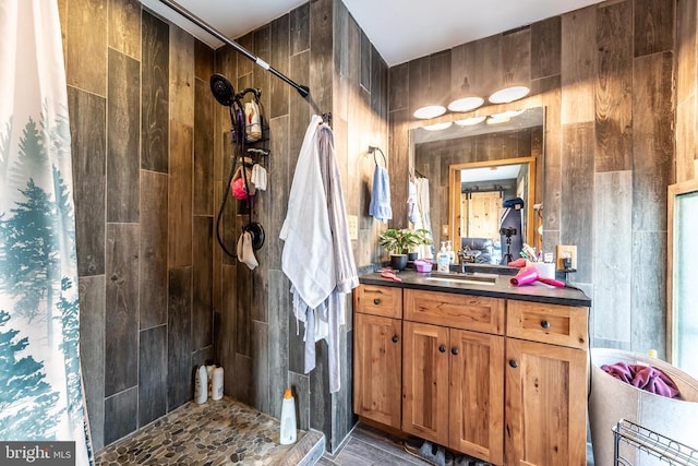 full bathroom featuring a tile shower and vanity