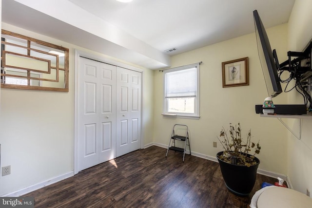 interior space with baseboards, a closet, visible vents, and dark wood-type flooring