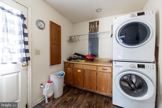 laundry room with cabinet space, dark wood-style flooring, and stacked washer / dryer