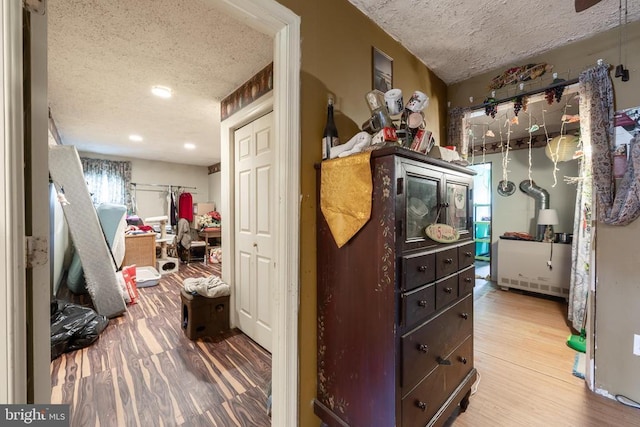 interior space with a textured ceiling and wood finished floors