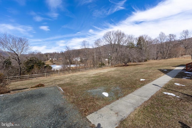 view of yard with fence and a rural view