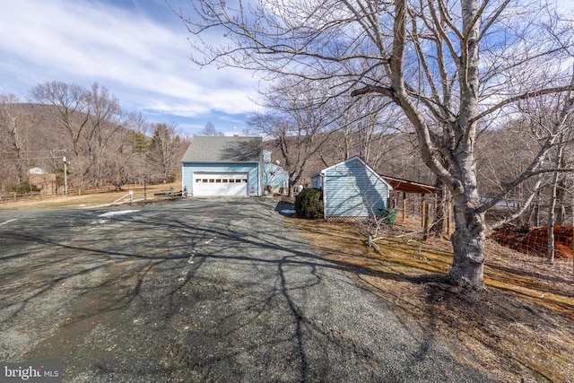 view of property exterior with an outbuilding and a detached garage