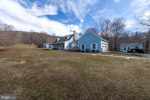 view of side of home with a yard, a chimney, and an attached garage