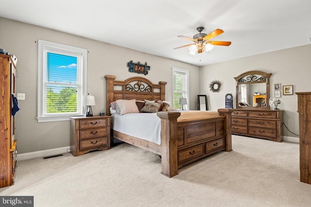 bedroom featuring light carpet, baseboards, and ceiling fan