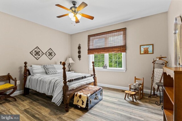 bedroom featuring baseboards, wood finished floors, and ceiling fan