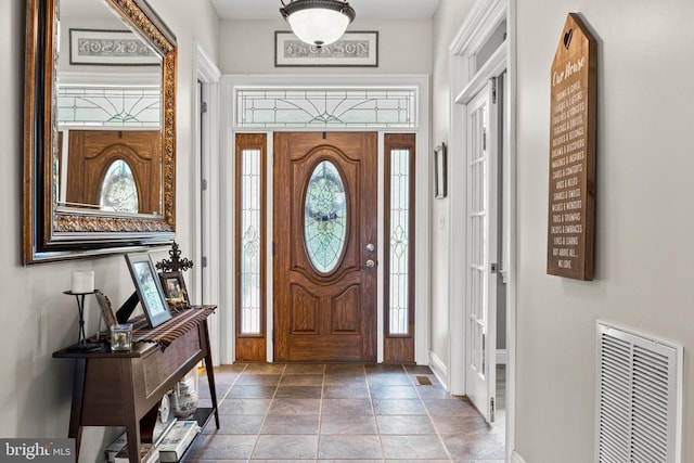 entrance foyer featuring baseboards and stone finish flooring
