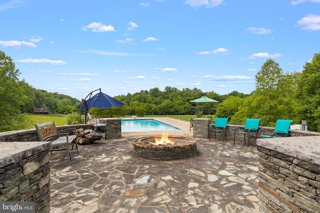 swimming pool featuring an outdoor fire pit and a patio