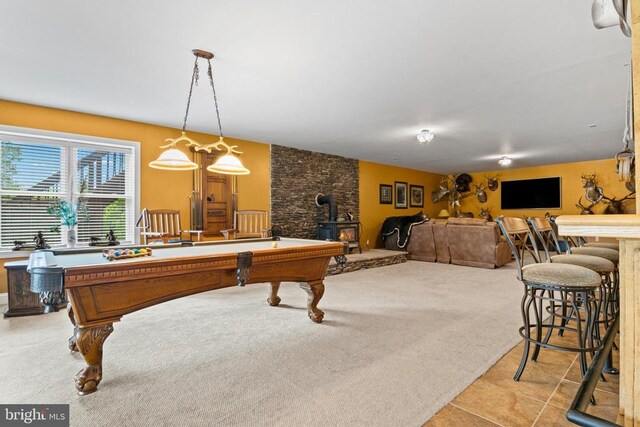 game room featuring a wood stove, carpet floors, pool table, and tile patterned floors