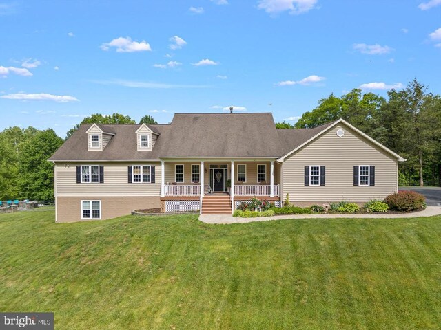 cape cod home featuring covered porch and a front lawn