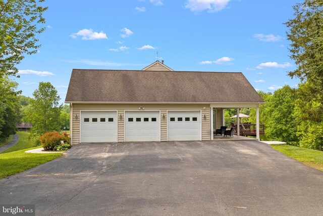 garage featuring asphalt driveway