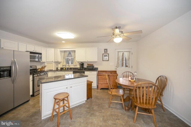 6117 Block House Rd, Partlow, VA 22534 - kitchen featuring stainless steel appliances, white cabinets, dark countertops, a center island, and ceiling fan