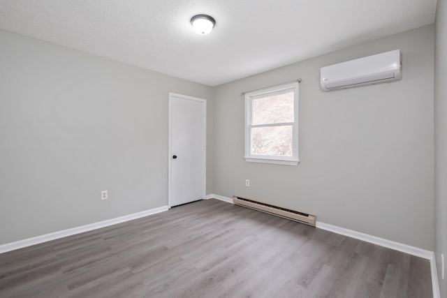 129 Hillwood Dr, Front Royal, VA 22630 - spare room with baseboard heating, an AC wall unit, and wood finished floors