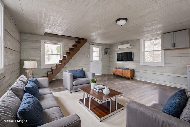 129 Hillwood Dr, Front Royal, VA 22630 - living room with stairs, a wall mounted air conditioner, wood finished floors, and wooden walls