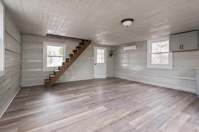 129 Hillwood Dr, Front Royal, VA 22630 - below grade area with stairs, a wall mounted AC, wood finished floors, and wooden walls