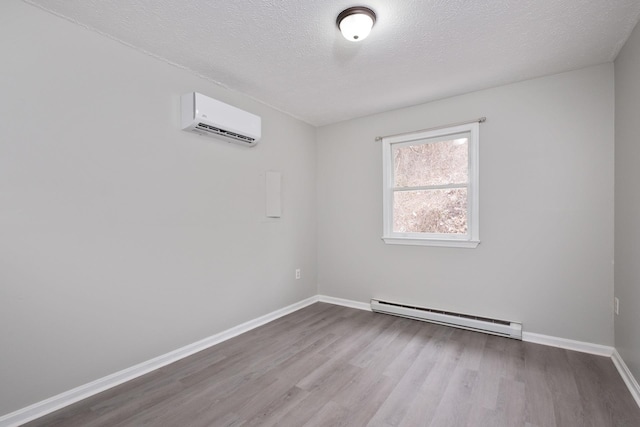 129 Hillwood Dr, Front Royal, VA 22630 - empty room featuring a baseboard radiator, an AC wall unit, wood finished floors, and a textured ceiling