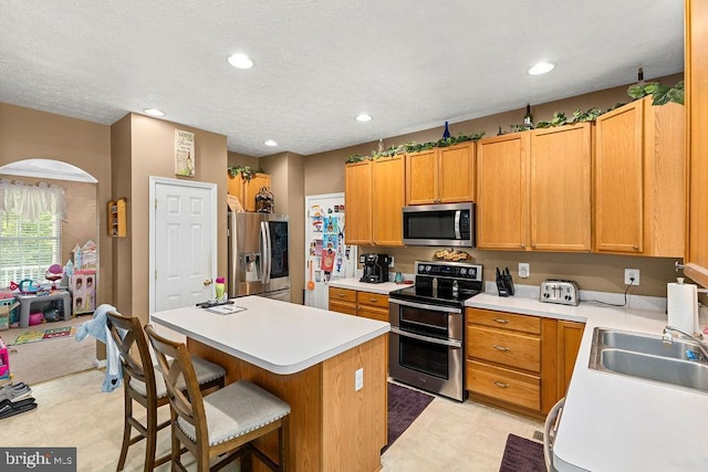 12407 Salient Ln, Spotsylvania, VA 22551 - kitchen featuring stainless steel appliances, light countertops, a breakfast bar, a center island, and recessed lighting