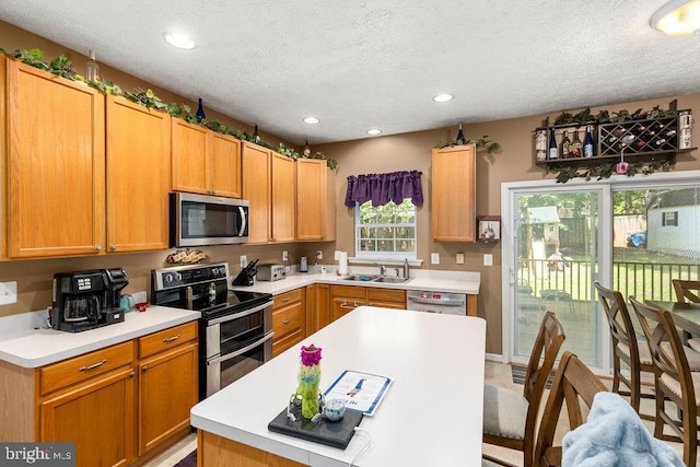 12407 Salient Ln, Spotsylvania, VA 22551 - kitchen featuring appliances with stainless steel finishes, a textured ceiling, light countertops, and recessed lighting