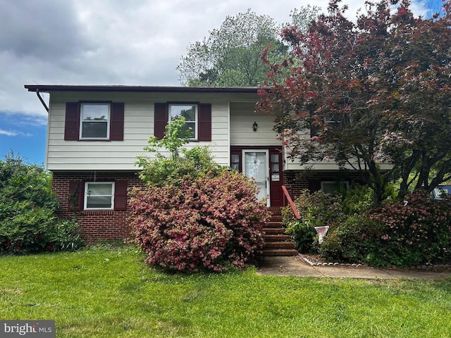 bi-level home with brick siding and a front lawn