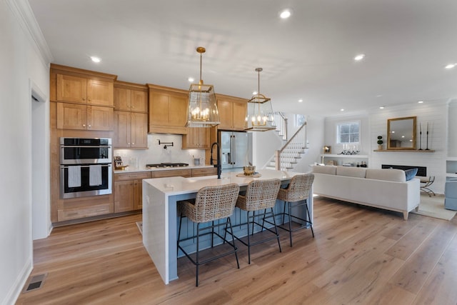 1115 Sablewood Dr, Charlottesville, VA 22911 - kitchen featuring a breakfast bar, a center island with sink, crown molding, light countertops, and appliances with stainless steel finishes