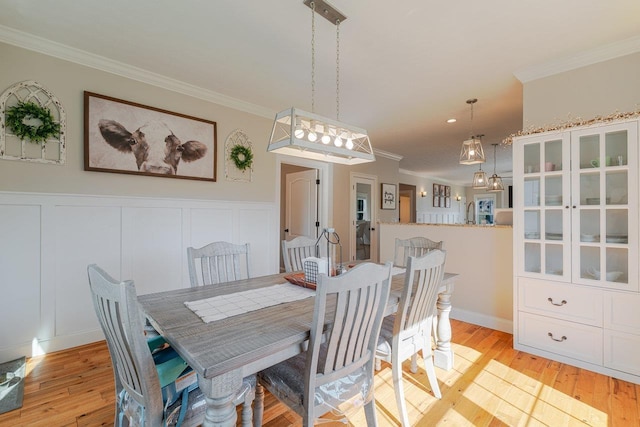 731 Hidden Brook Rd, Mcgaheysville, VA 22840 - dining area featuring crown molding, light wood-type flooring, wainscoting, a chandelier, and a decorative wall