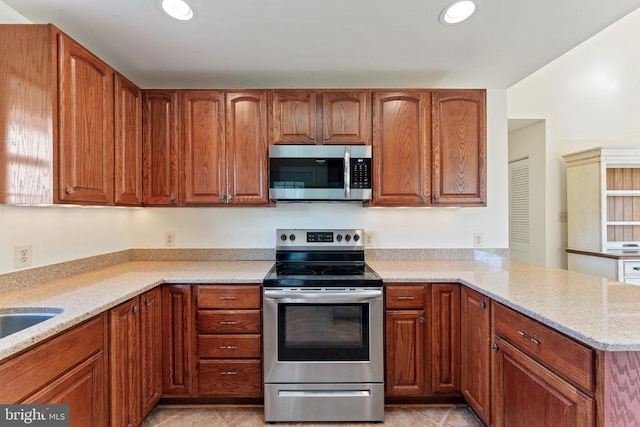  - kitchen with stainless steel appliances, a peninsula, light tile patterned floors, light stone counters, and recessed lighting