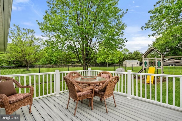  - wooden deck with a playground, outdoor dining space, and a fenced backyard