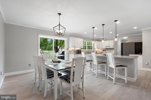  - dining room featuring ornamental molding, light wood-style flooring, recessed lighting, and a chandelier