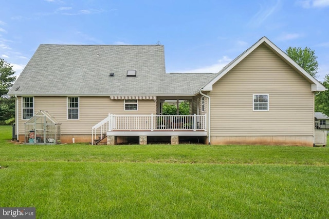  - rear view of house with a deck, a lawn, an exterior structure, and a shingled roof