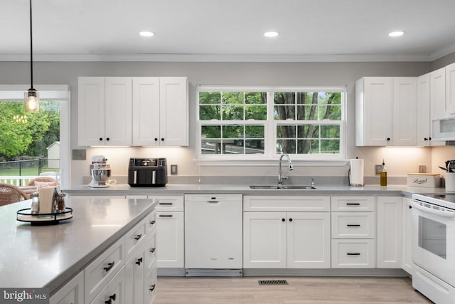  - kitchen with white appliances, white cabinetry, plenty of natural light, light countertops, and recessed lighting
