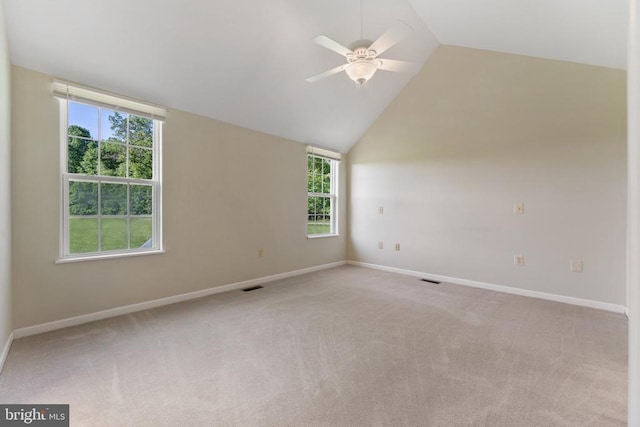  - empty room with ceiling fan, light colored carpet, vaulted ceiling, and plenty of natural light
