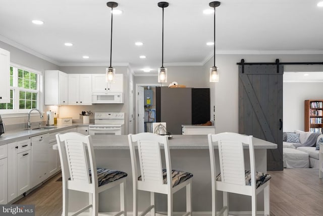  - kitchen featuring white appliances, light wood finished floors, ornamental molding, open floor plan, and light countertops