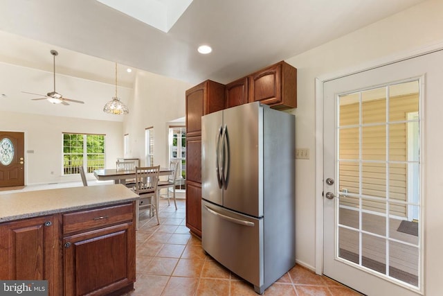  - kitchen featuring freestanding refrigerator, a ceiling fan, light tile patterned floors, light countertops, and hanging light fixtures