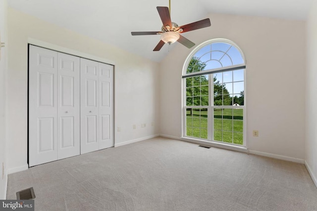  - unfurnished bedroom featuring vaulted ceiling, carpet flooring, a closet, and a ceiling fan