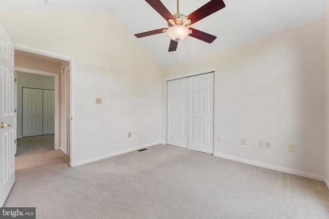  - unfurnished bedroom with lofted ceiling, light colored carpet, a closet, and a ceiling fan