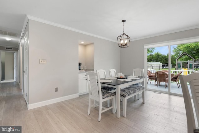 - dining space featuring crown molding, light wood-style flooring, and a chandelier