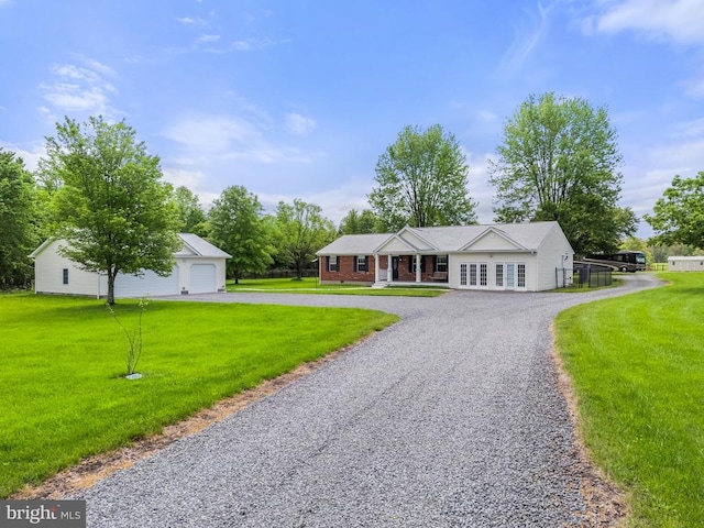  - single story home with a front lawn, an outbuilding, and a detached garage
