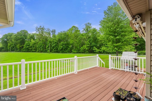 - wooden deck featuring a lawn