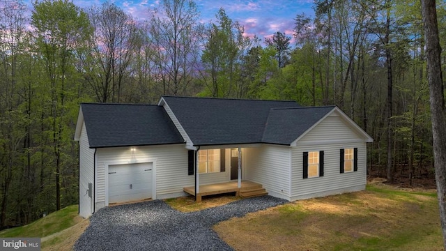 358 Hemlock Ln, Mineral, VA 23117 - view of front of house with an attached garage, gravel driveway, roof with shingles, and a wooded view