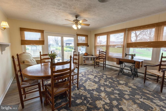 dining area featuring ceiling fan, a textured ceiling, wood finished floors, and healthy amount of natural light