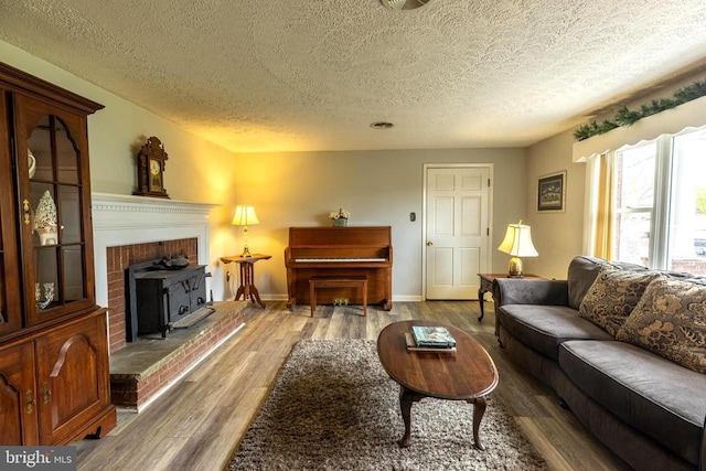 living area featuring a textured ceiling, wood finished floors, and baseboards