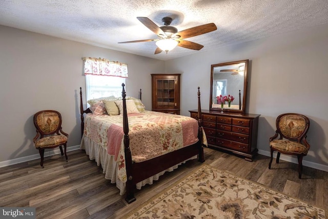 bedroom featuring wood finished floors, a textured ceiling, baseboards, and ceiling fan