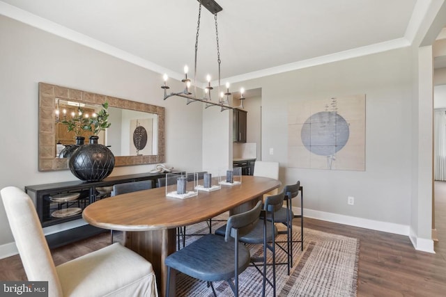  - dining room featuring a chandelier, baseboards, crown molding, and dark wood-style flooring