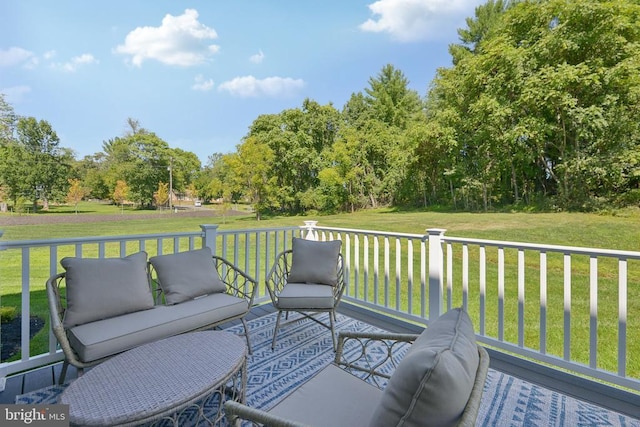  - wooden deck with a lawn, an outdoor living space, and view of wooded area