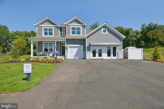  - view of front facade with a porch, a front yard, driveway, board and batten siding, and a garage