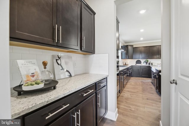  - bar with ornamental molding, light wood-style flooring, and tasteful backsplash