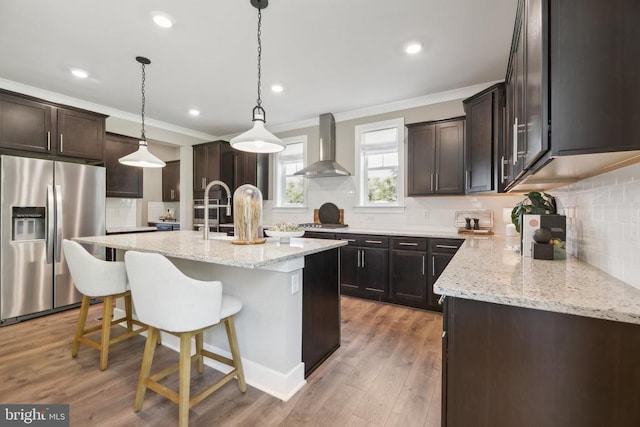  - kitchen featuring appliances with stainless steel finishes, a sink, crown molding, a kitchen island with sink, and hanging light fixtures