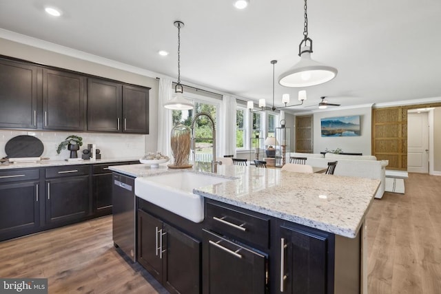  - kitchen with a sink, stainless steel dishwasher, open floor plan, a kitchen island with sink, and backsplash